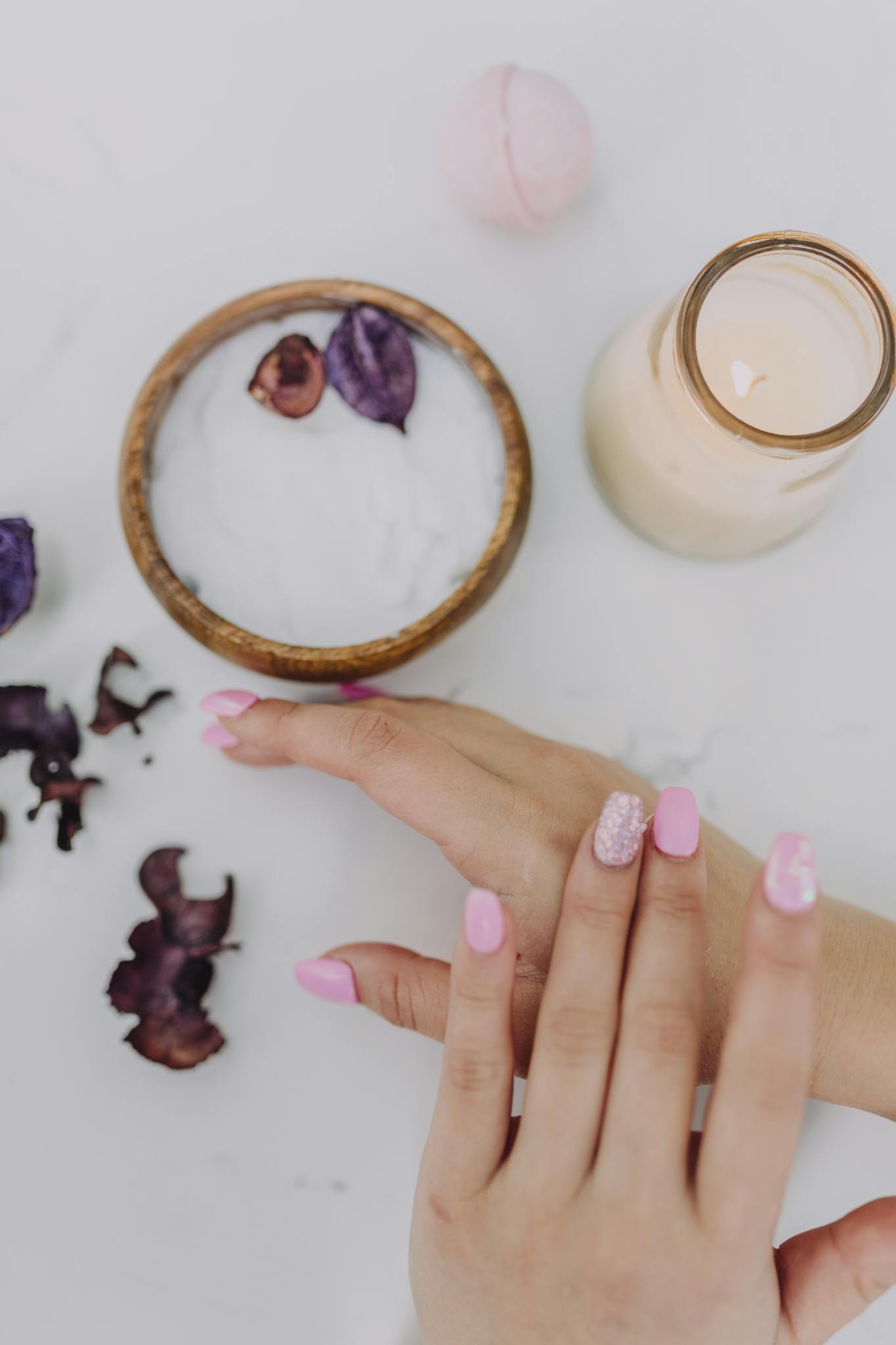 Beautiful pink manicure and spa products create a calming and luxurious experience.